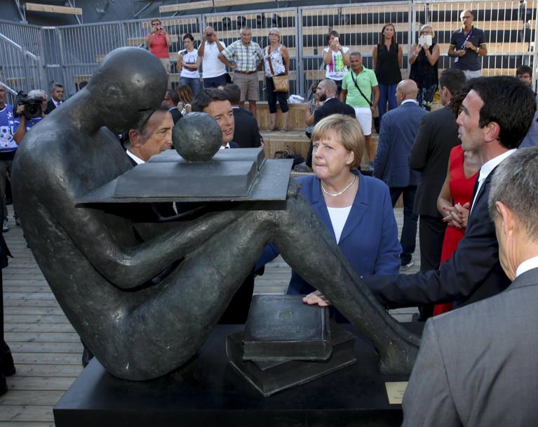 Il cancelliere tedesco osserva un&#39;opera scultorea (Ansa)